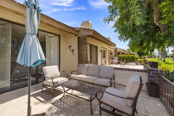 a view of a patio with couches table and chairs and potted plants