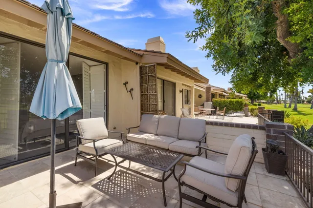 a view of a patio with couches table and chairs and potted plants