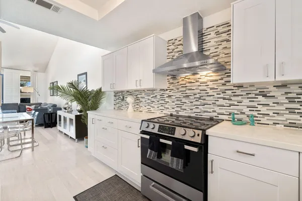 a kitchen with a stove and white cabinets