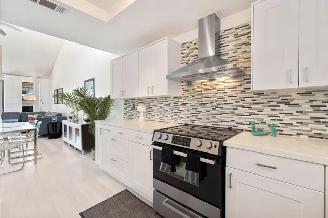 a kitchen with a stove and white cabinets
