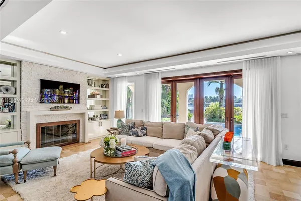 a living room with furniture a flat screen tv and a fireplace