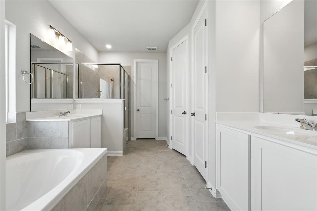 2515 Ridgecrest Lane Sherman, TX 75092 - Photo 16 of 40 Full bathroom with two vanities, a stall shower, a bath, tile patterned flooring, and a closet