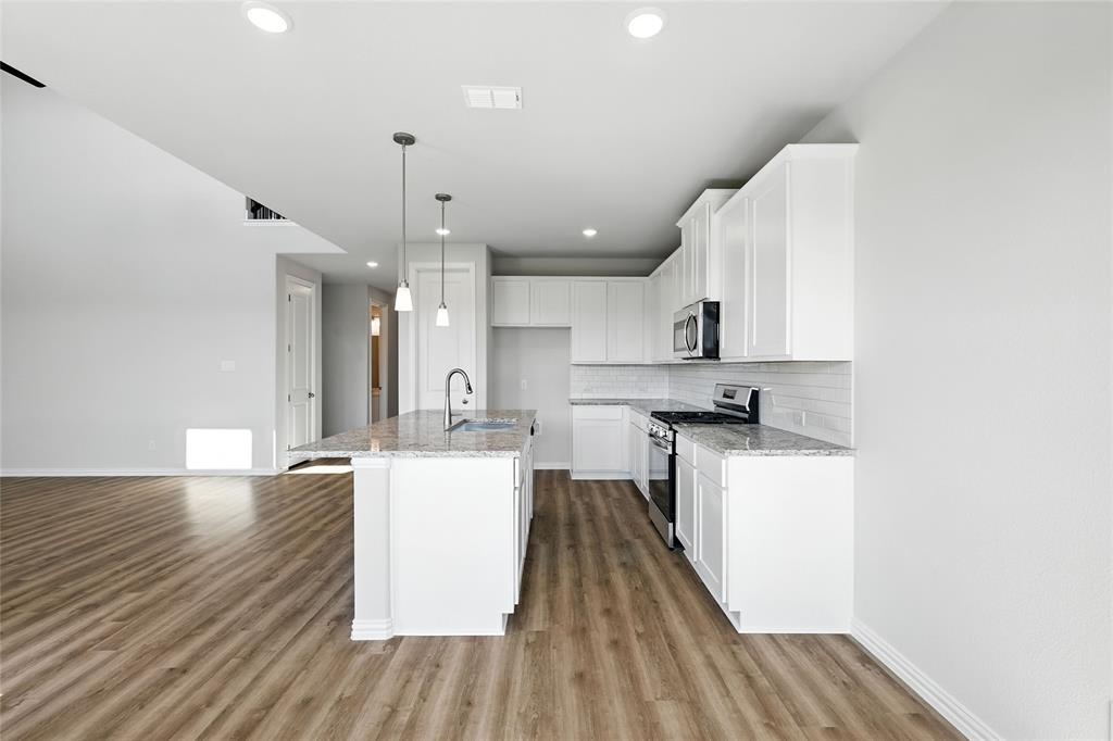 2515 Ridgecrest Lane Sherman, TX 75092 - Photo 3 of 40 Kitchen with backsplash, stainless steel appliances, light stone counters, light wood-style floors, and recessed lighting