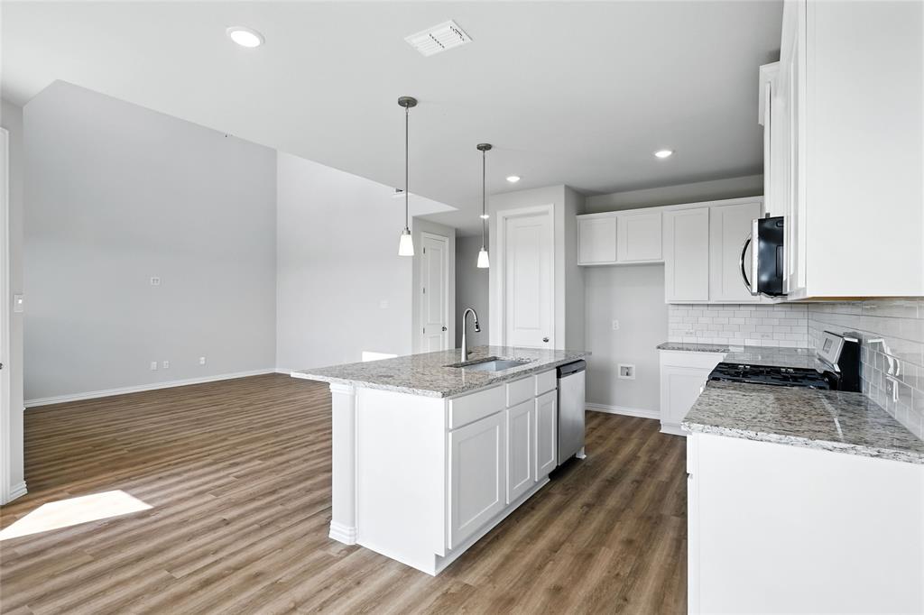 2515 Ridgecrest Lane Sherman, TX 75092 - Photo 4 of 40 Kitchen with white cabinets, backsplash, light wood-style floors, recessed lighting, and stainless steel appliances
