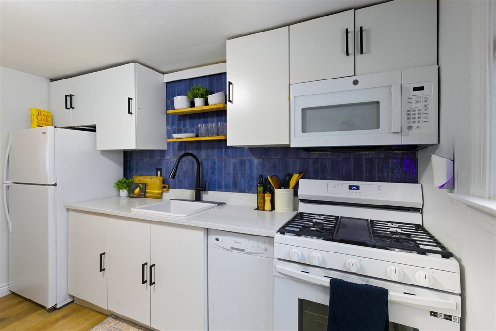 5 Lewis Farm Road, Unit 5 Dedham, MA 02026 - Photo 10 of 18 a kitchen with a white cabinets and white appliances