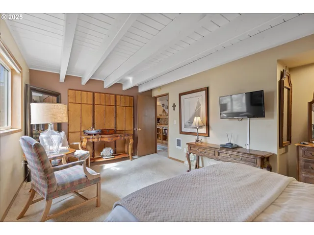 a bedroom with furniture a flat screen tv and large window