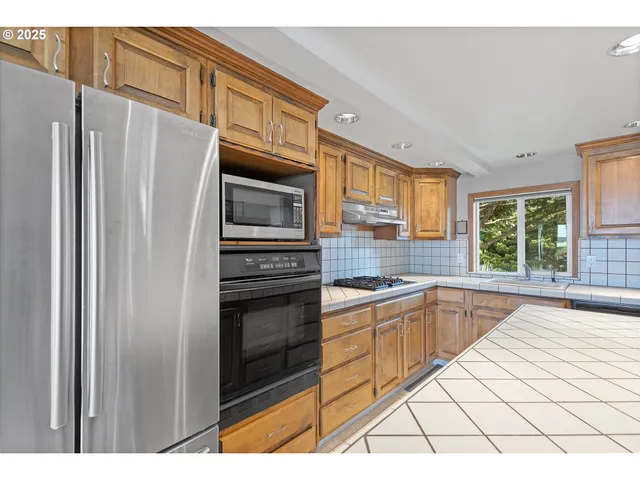 a kitchen with granite countertop a refrigerator and a sink