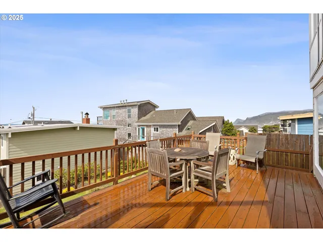 a balcony with wooden floor table and chairs