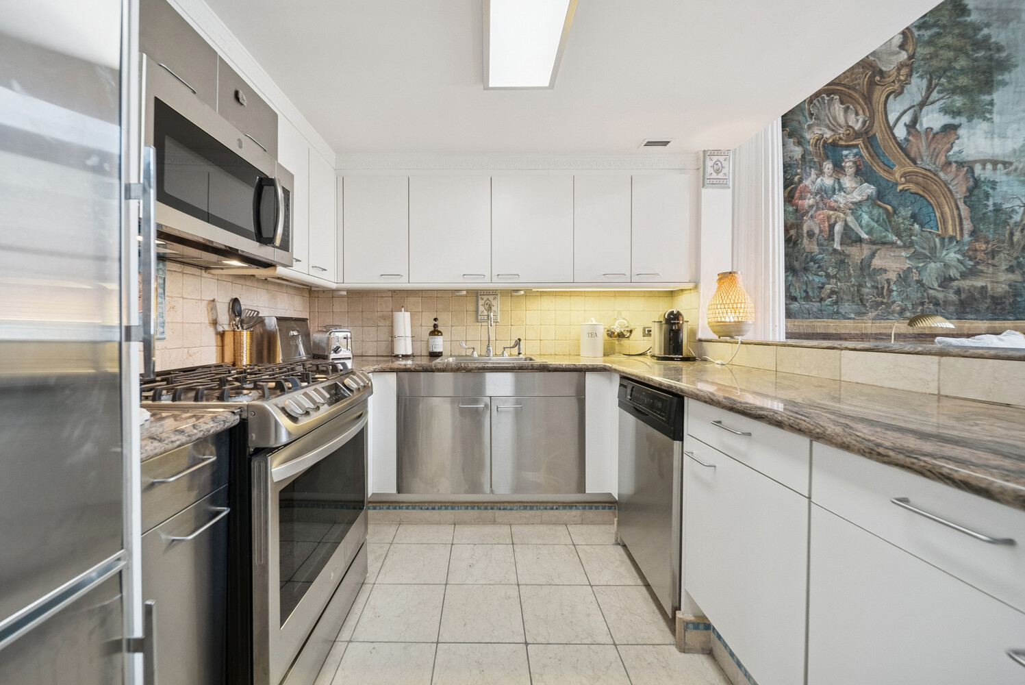 240 Centre Street, Unit 3B Manhattan, NY 10013 - Photo 19 of 20 a kitchen with stainless steel appliances granite countertop a stove a sink and a microwave