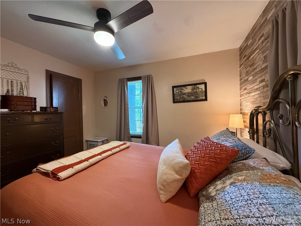 154 Taylor Road Barberton, OH 44203 - Photo 24 of 36 Primary bedroom with large bed, window, and lovely wood decorative wall and open door.