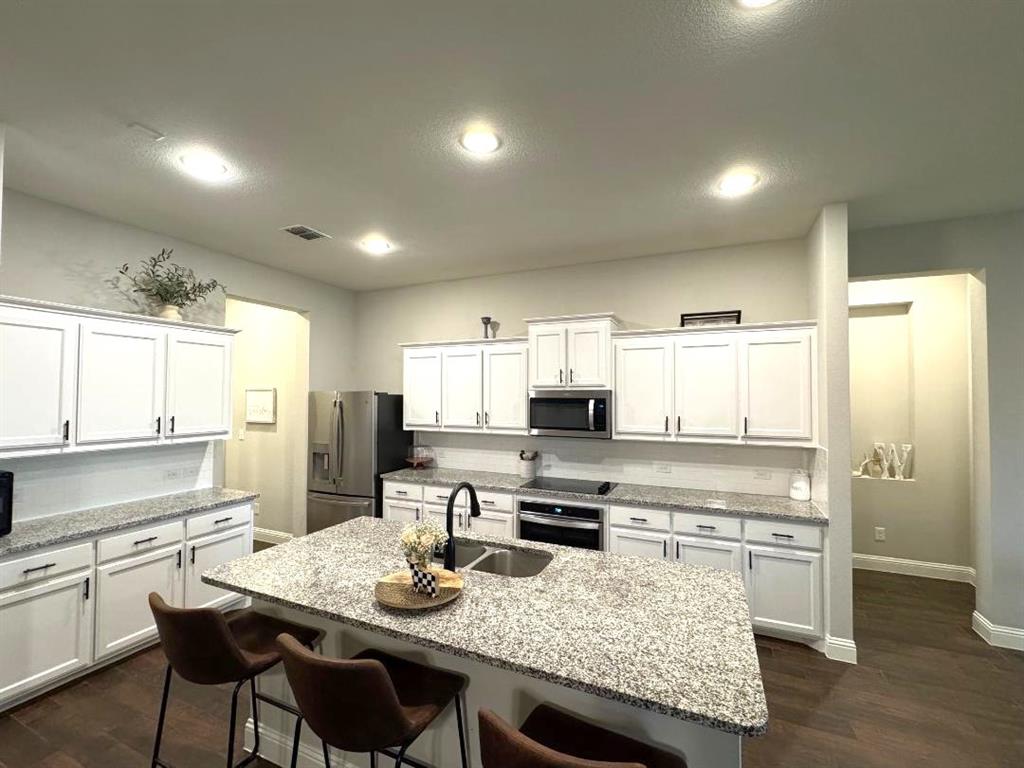 1455 Radecke Road Krum, TX 76249 - Photo 5 of 18 a kitchen with stainless steel appliances granite countertop a stove refrigerator sink and cabinets