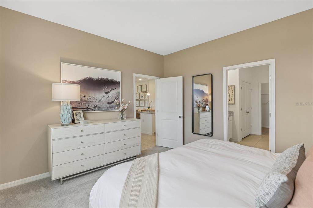 3851 Rising Trail Davenport, FL 33837 - Photo 19 of 39 a spacious bedroom with a bed and a mirror