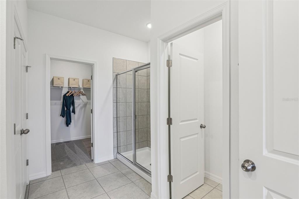 3851 Rising Trail Davenport, FL 33837 - Photo 25 of 39 a bathroom with a shower and a glass door