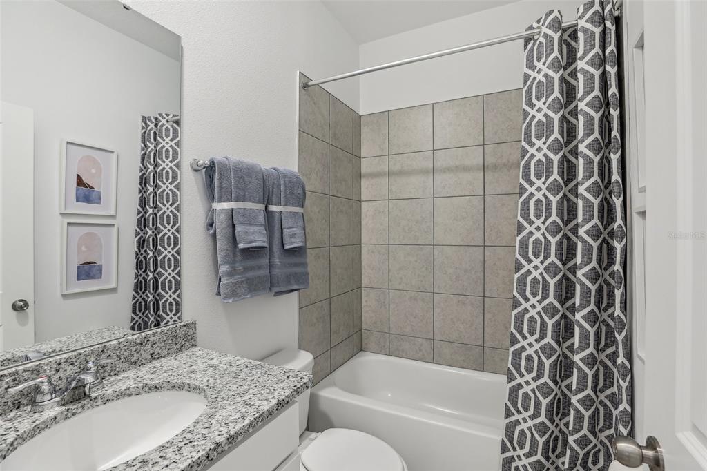 3851 Rising Trail Davenport, FL 33837 - Photo 30 of 39 a bathroom with a granite countertop bathtub sink vanity and shower