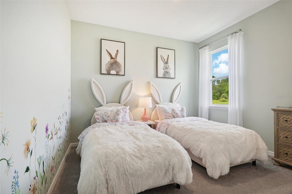 3851 Rising Trail Davenport, FL 33837 - Photo 32 of 39 a bedroom with two beds and a painting on the wall