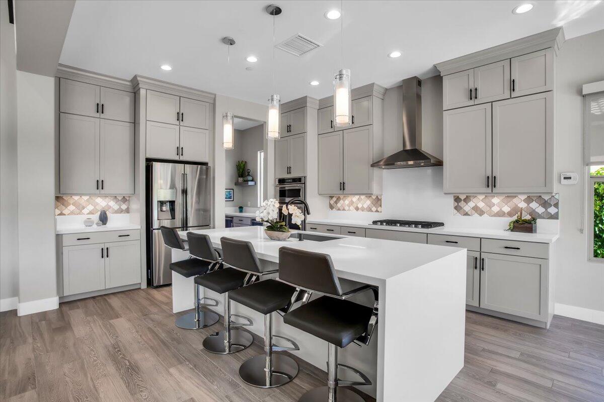 74 Barolo Rancho Mirage, CA 92270 - Photo 13 of 56 a kitchen with white cabinets and stainless steel appliances