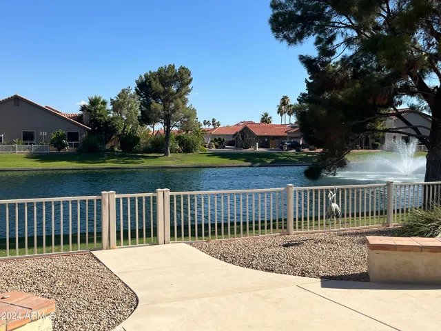 a front view of a house with a garden and lake view
