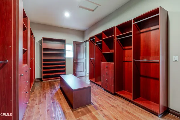 a view of walk in closet with clothes and shoes
