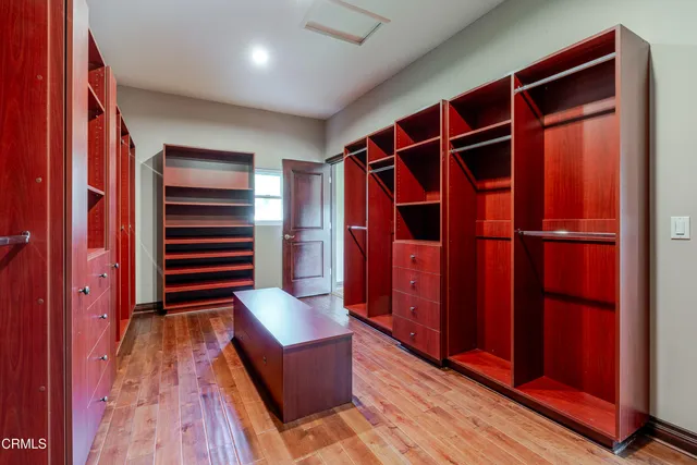 a view of walk in closet with clothes and shoes