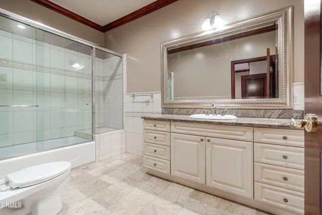 a bathroom with a sink and mirror with toilet