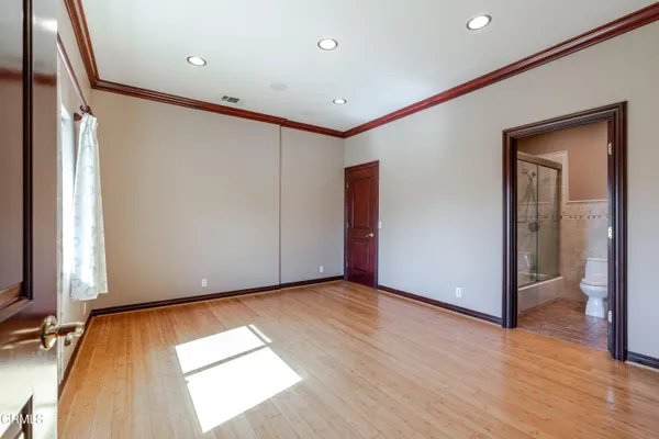 a view of empty room with wooden floor