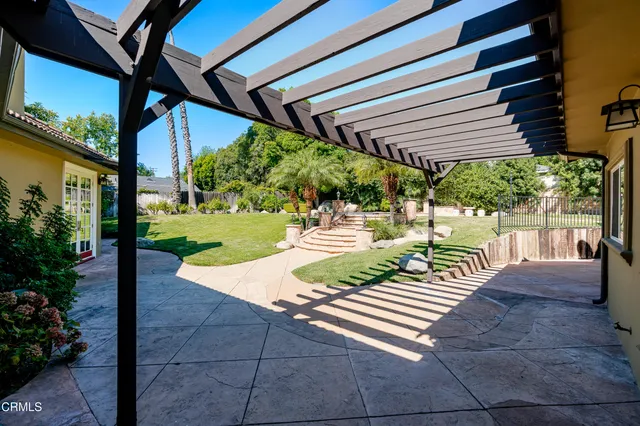 a view of a patio with table and chairs potted plants