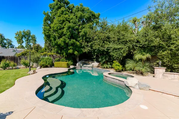 a swimming pool with some trees in the background