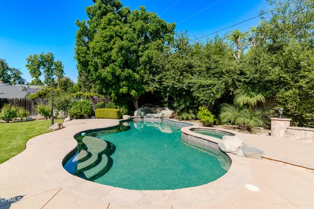 a swimming pool with some trees in the background