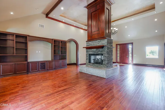 a view of a livingroom with wooden floor and a fireplace