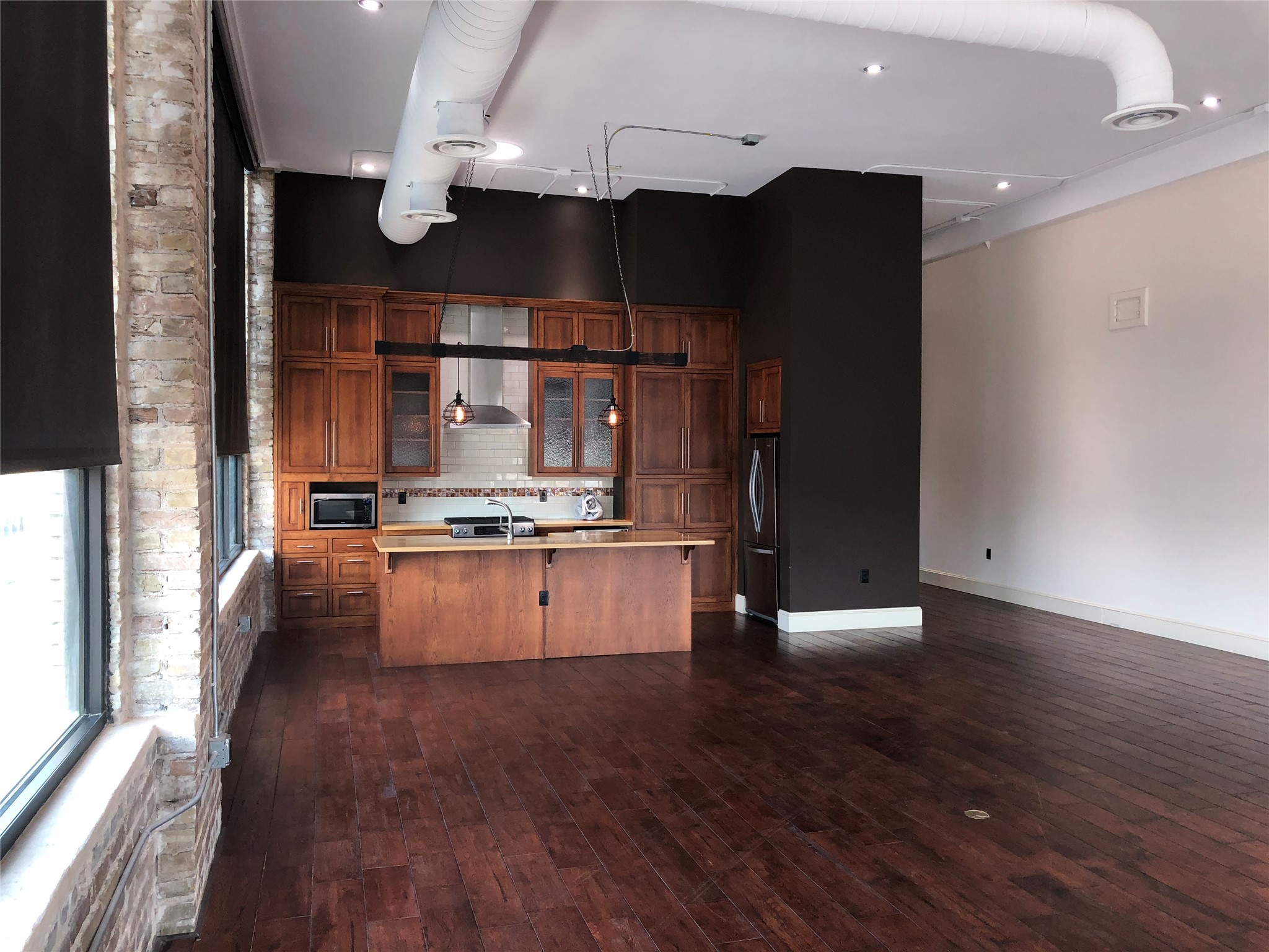 110 West 2nd Street, Unit LOFT B Taylor, TX 76574 - Photo 4 of 11 a view of kitchen with refrigerator and wooden floor