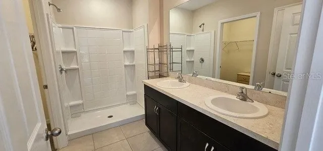 a bathroom with a shower sink vanity granite and mirror