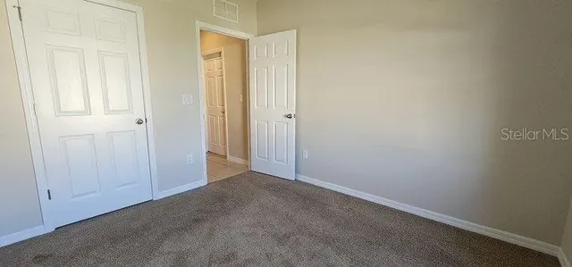 an empty room with windows and closet