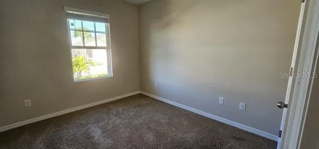 an empty room with fan and entrance