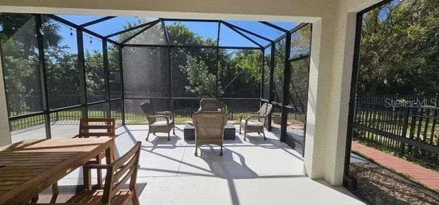 a view of a patio with table and chairs under an umbrella with a small yard