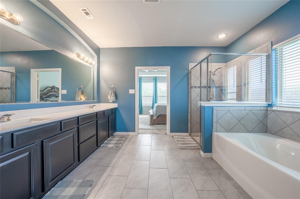 4542 Kipling Avenue Aubrey, TX 76227 - Photo 15 of 34 a spacious bathroom with a tub sink and mirror