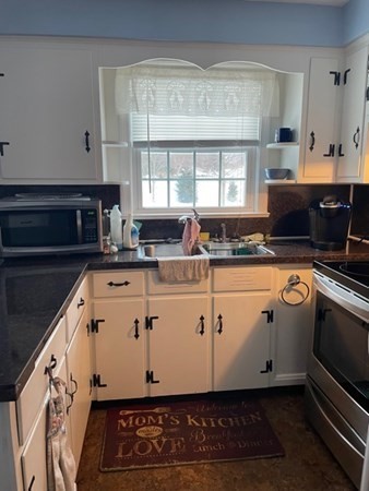 70 Woodcrest Road Springfield, MA 01129 - Photo 8 of 22 a view of kitchen with granite countertop a stove a sink a window and white cabinets