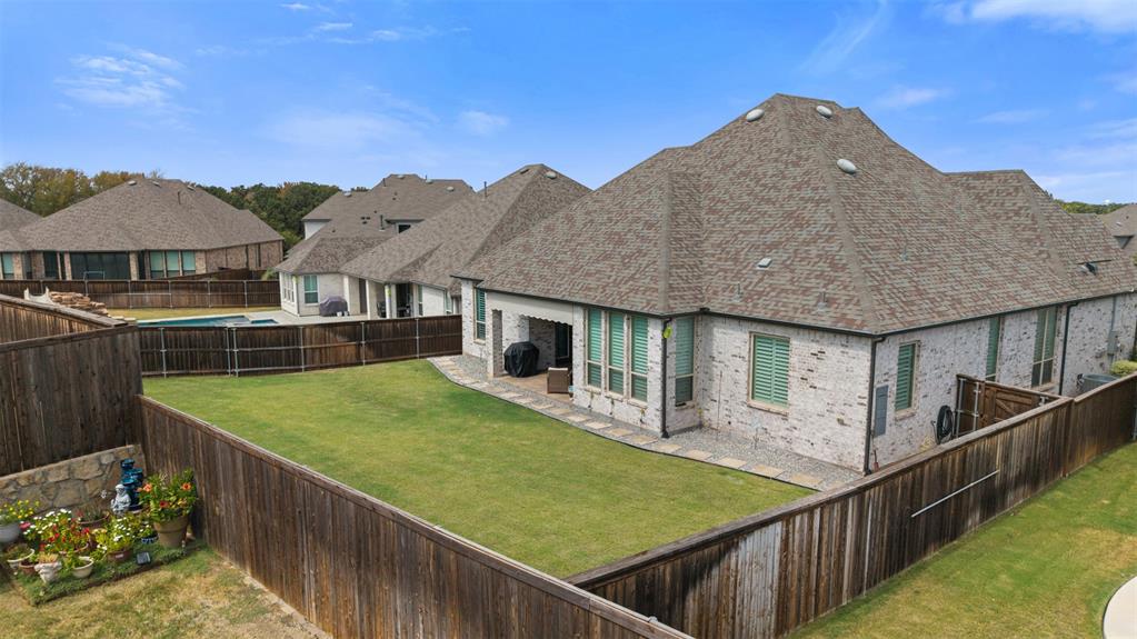9716 Wilderness Road Little Elm, TX 75068 - Photo 3 of 39 Private fenced backyard with a manicured lawn, stone paver cover patio