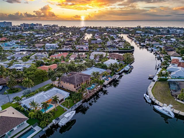 an aerial view of a city with lots of residential buildings ocean and mountain view in back