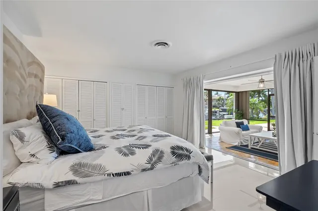 a bed sitting in a bedroom next to a window with balcony view