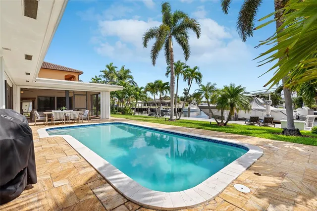 a view of swimming pool with lawn chairs and plants