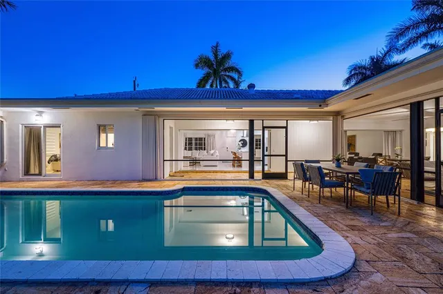 a living room with table chairs and a chandelier