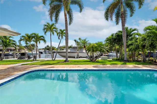 a view of swimming pool with palm trees