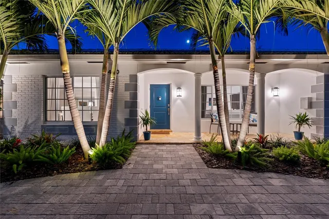 a view of house with a yard and potted plants