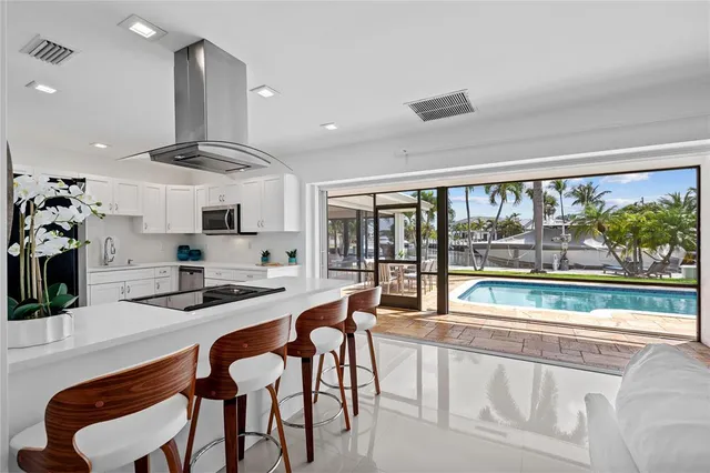 a kitchen with stainless steel appliances granite countertop a stove and white cabinets