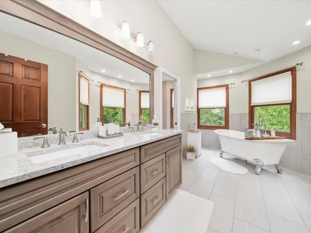 a bathroom with a granite countertop sink mirror and a large window