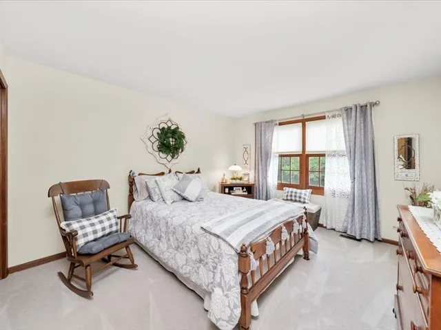 a bedroom with a bed chair and window