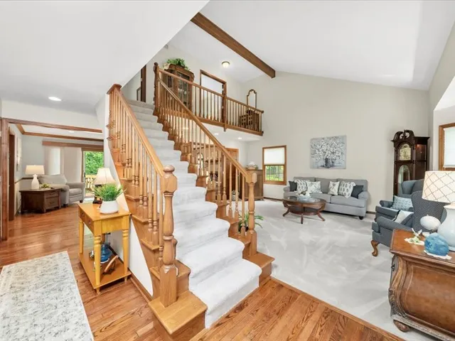 a living room with couches and a dining table with wooden floor