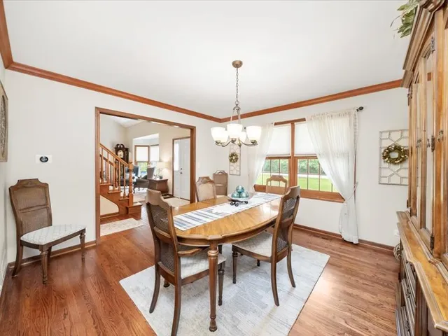 a dining room with furniture a chandelier and wooden floor