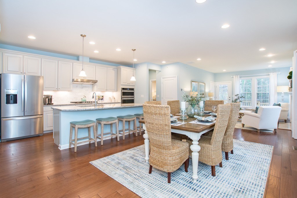 a dining room with stainless steel appliances a dining table chairs and kitchen view
