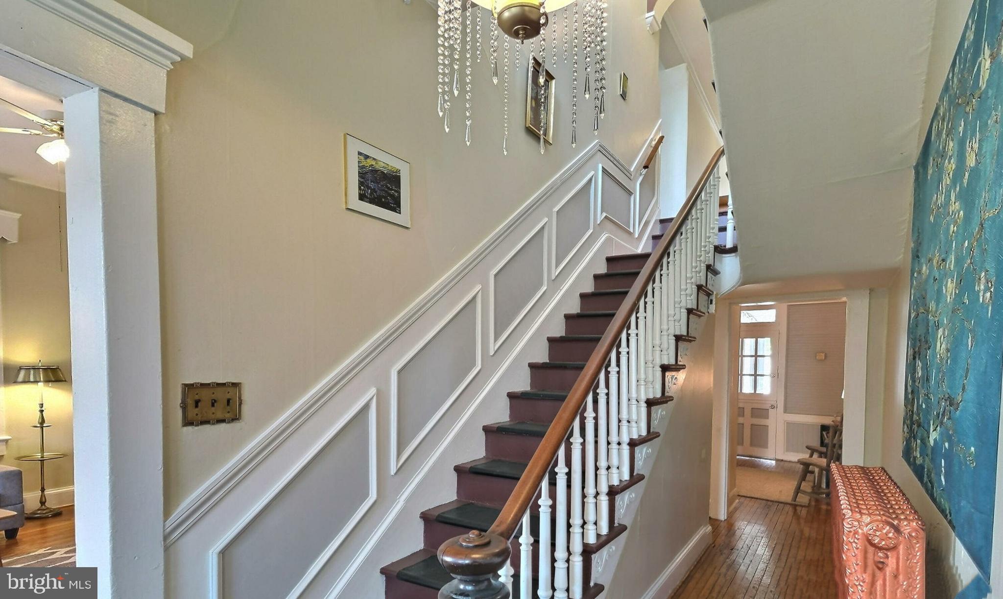 a view of staircase with lots of frames on wall and windows